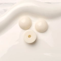 Vue macro de trois cabochons ronds en résine acrylique crème sur un plateau blanc - Blanc