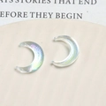Macro shot of iridescent resin crescent moon charms with glitter finish and aurora glow - Aurora Clear