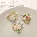 Close-up of handmade beaded glass flower charms in soft pink and green tones - Pink