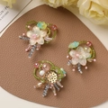 Macro detail of handmade gradient flower charms with beads and metal DIY mounting base - Green