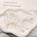 Detail view of handmade beaded bow earrings with pink crystal pendants on ceramic plate - White Pink White Teardrop Style
