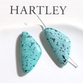 Detailed macro of sky blue triangular turquoise beads with dark ink splatter texture - 1 Piece / Blue