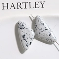 Close-up of white triangle turquoise beads with black ink splatter for DIY jewelry making - 1 Piece / White