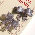 Close-up of sparkling acrylic bow accessories with colorful sequins for DIY jewelry - Gray