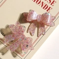 Macro detail of glittery pink acrylic bow accessories for DIY hairpins and earrings - Pink