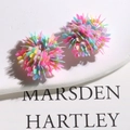 Close-up of colorful floral sequin earrings in pink, mint, blue, and yellow petals - Frosted Green Glass Bead Style