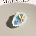 Dettaglio macro di accessorio conchiglia oceanica con stella marina e cristallo a cuore - Stile Blu (Dimensione Casuale)