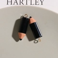 Close-up of cute pencil-shaped resin charms with gold rings for DIY earring making - Black