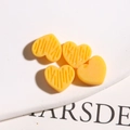 Macro-opname van gele hartvormige harsbedeltjes met textuurstrepen voor DIY-sieraden - Geel