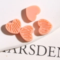 Detail van roze hars hartvormige bedeltjes met gestreepte en gladde texturen voor DIY - Oranje