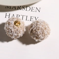 Close-up of mixed beige teddy fleece plush charms with golden metal shanks for DIY crafts - Brown
