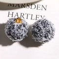 Close-up of curly plush teddy wool charms with gold metal rings for DIY jewelry making - Black