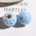 Close-up of light blue curly teddy fur pom-poms with gold shanks for DIY crafts - Sky Blue