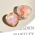 Macro shot of iridescent gradient heart charms and pink resin decorative accessories - Orange