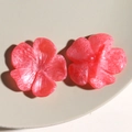 Makroaufnahme von Harzblumen-Anhängern mit orangefarbener Marmortextur für DIY-Schmuck - Rosenrot