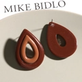 Colgantes de resina en forma de gota en color marrón y caramelo sobre una bandeja decorativa - Café Marrón