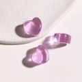 Macro shot of three purple translucent heart-shaped resin charms with subtle glitter - Purple