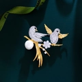 Detalle macro de broche de pájaros con circonitas, perla grande y acabado dorado - Dorado (XZ3007)