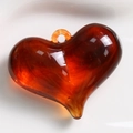 Macro detail of amber resin heart pendant with artistic marble pattern and top loop - Amber Marbled