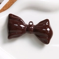 Détail d'un grand pendentif nœud marron foncé avec finition brillante et trou d'attache - Marron
