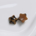 Macro-opname van luipaardprint en amberkleurige harssterren voor DIY-sieraden - Pentagram / Donkere Koffie