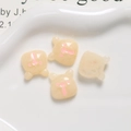 Macro shot of four cream-yellow resin bears on a ceramic tray for DIY craft accessories - Smudged Cream White