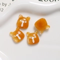 Macro shot of amber orange bear-shaped resin flatback charms for DIY crafts and accessories - Marbled Coffee