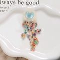Macro view of colorful tassel beads with sequins and heart mink fur on white tray - Light Blue