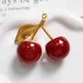 Macro shot of glittery red resin cherry pendant with golden metal leaf and ring - Red Matte Stem
