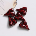 Détail macro de cinq pendentifs en forme de cœur rouge léopard pour bijoux DIY - Rouge