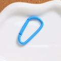 Macro view of bright blue D-ring spring buckle on white tray with cork background - Dark Blue