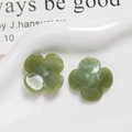 Macro shot of green resin four-leaf clover charms with marble texture on display - Green