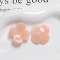 Macro shot of pink resin four-petal flower charms for DIY jewelry on a white ceramic tray - Light Pink