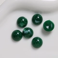 Vista macro di cabochon in resina verde smeraldo da 12mm con trama marmorizzata per gioielli - Verde