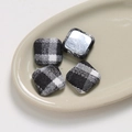 Detail of square black and white checkered fabric buttons with smooth metal backing - Square Black