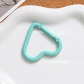Detail of mint green heart-shaped spring clasp on a white wavy ceramic display plate - Lake Blue