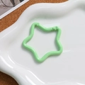 Detail of a pastel green star-shaped spring lobster clasp on a white cloud tray - Light Green