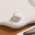 Vista detallada de un llavero de béisbol mini en cuero blanco con costuras rojas a mano - Blanco