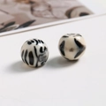 Detalle macro de cuentas redondas de resina con acabado de estampado de leopardo premium - Blanco