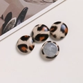 Detail of round leopard print leather buttons with silver metal back for DIY crafts - White Coffee Glossy