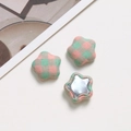 Nahaufnahme sternförmiger Stoffknöpfe mit rosa-grünem Karomuster und Metallrückseite - Rosa und Grün Kariert