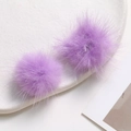 Macro shot of two soft 3.5cm lavender mink fur pom poms for DIY jewelry and hair accessories - Purple