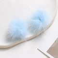 Close-up of fluffy light blue mink fur pom-poms on white ceramic plate for DIY crafts - Light Blue