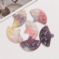 Detailed macro of translucent fan-shaped acrylic charms with floral relief for DIY jewelry - Gradient Orange Red