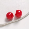 Macro shot of red ink-stained round resin beads with a high-gloss polished finish - Red