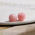 Makroansicht von zwei sanft rosa Resin-Cabochon-Perlen mit poliertem Glanzfinish - Rosa