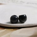 Macro shot of polished black resin spherical beads on a white textured tray for DIY jewelry - Small / 1 Piece / Black