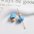 Macro shot of blue glass mushroom beads with polka dots and golden pendant pin detail - Blue with Brown Stem