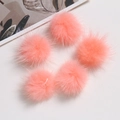 Close-up of five soft pink faux fur pompoms for DIY crafts and clothing accessories - Peach Pink