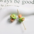 Macro shot of green glass mushroom beads with orange dots and gold metal pins for DIY jewelry - Grass Green with Brown Stem